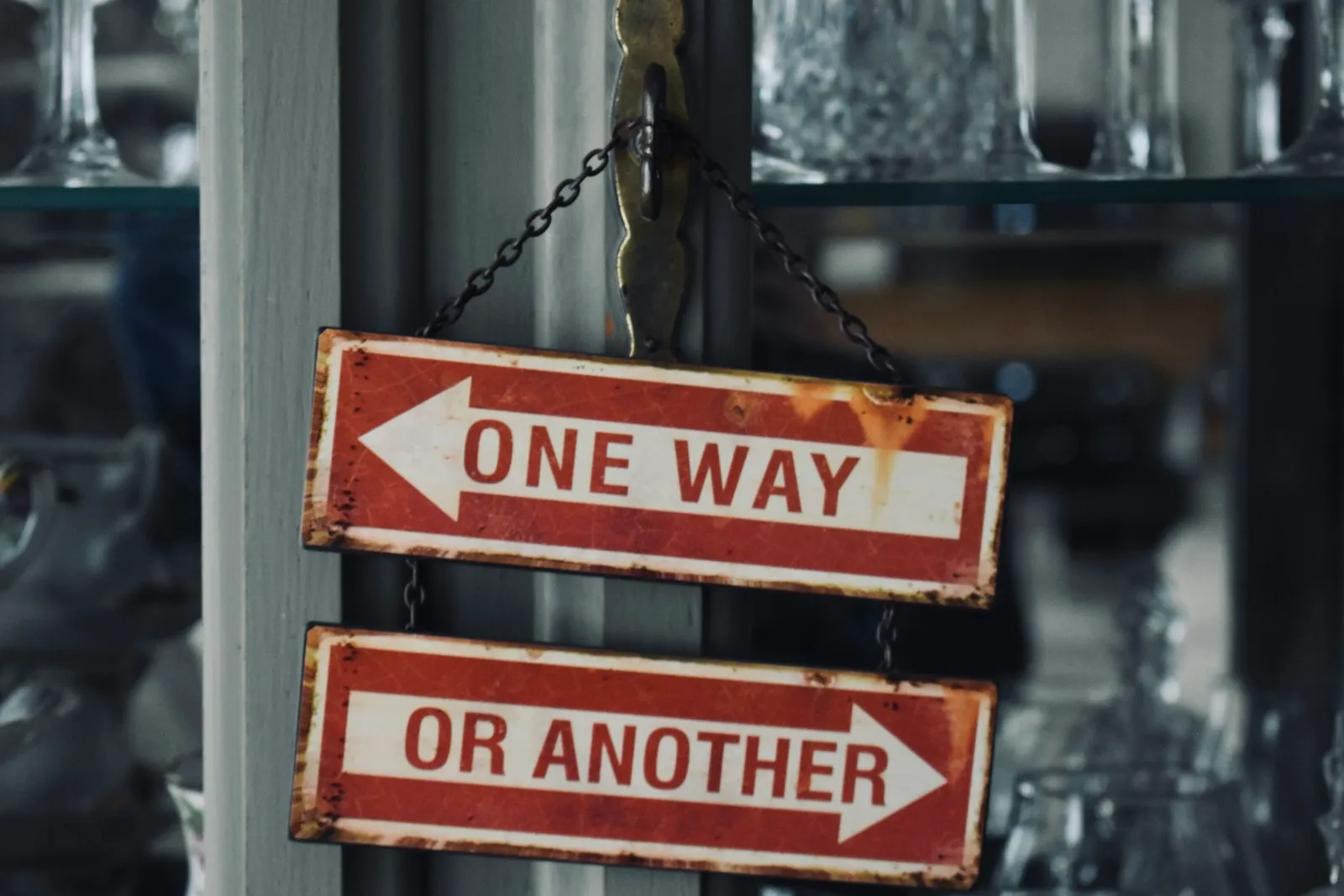 Deux panneaux « One Way » et « Or Another », flèches opposées, suspendus à un support métallique