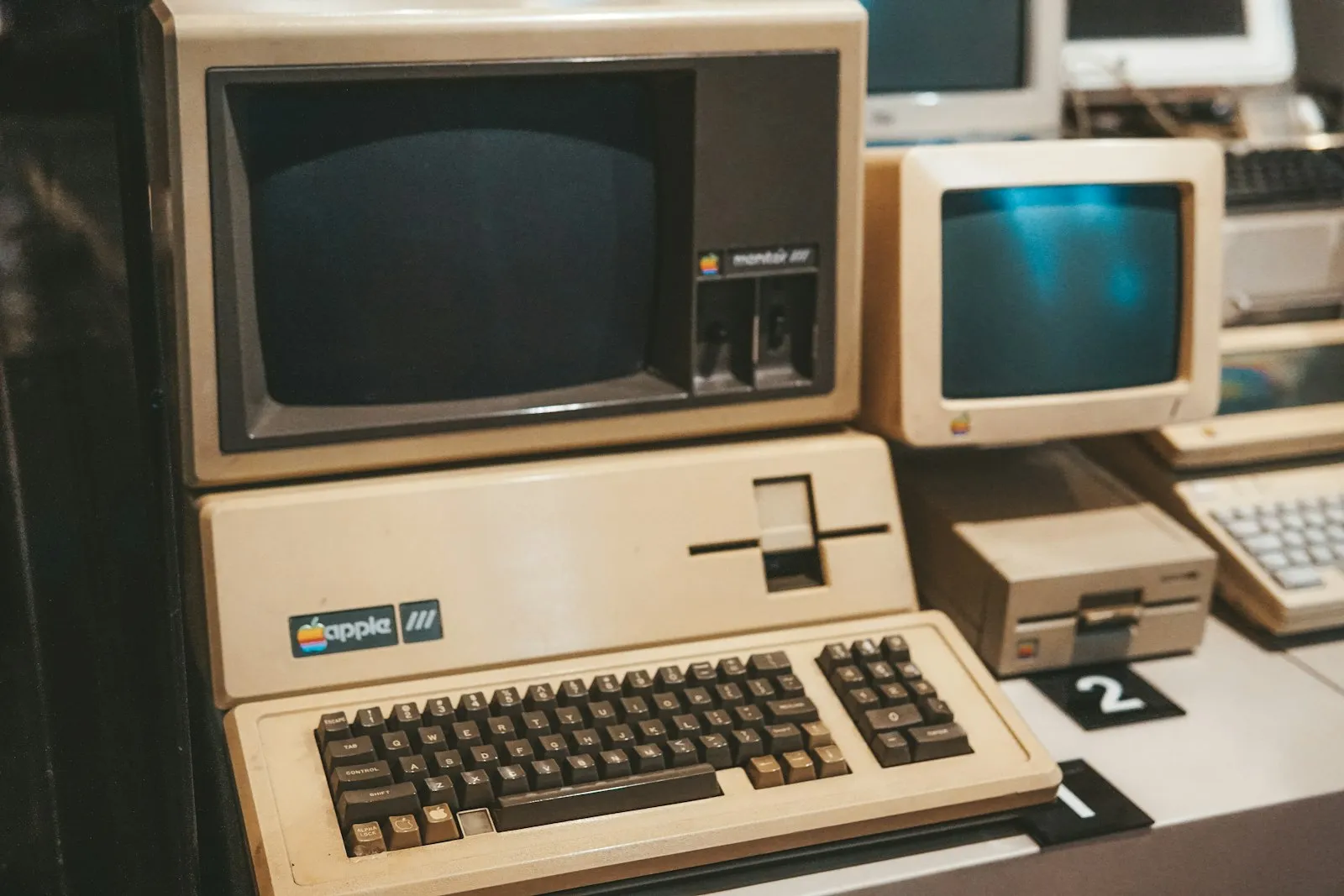 Une rangée de vieux ordinateurs posés sur un bureau — des logiciels métier qui ont vieilli